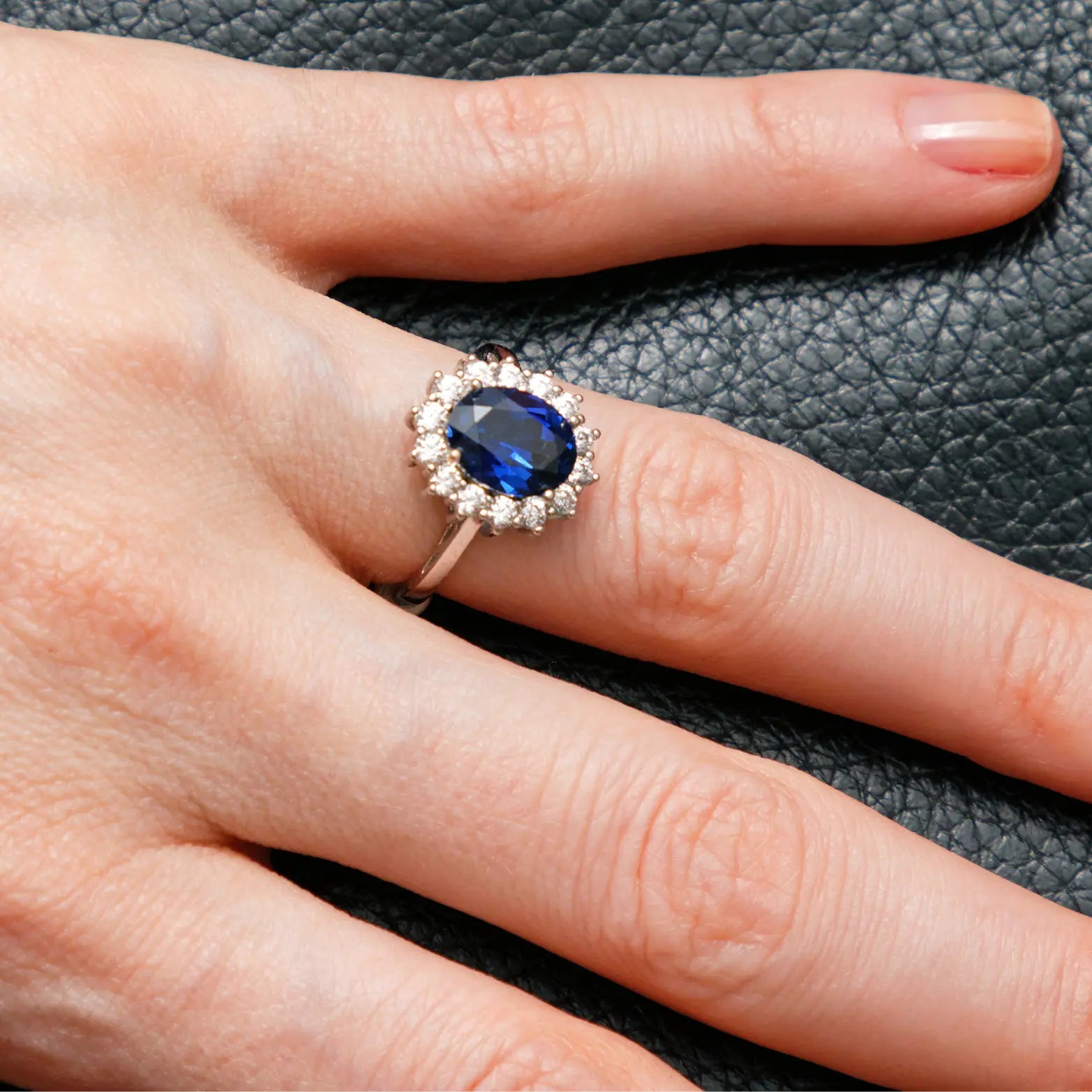 Bague sur-mesure sertie d’un saphir taille ovale, entouré de diamants éclatants, montée sur un anneau en or blanc 18 carats. Cette création illustre l’expertise en haute joaillerie et la possibilité d’imaginer et de concevoir un bijou unique sur mesure. Accompagnés par un artisan joaillier, les clients peuvent choisir la pierre précieuse – saphir, émeraude, rubis ou tourmaline – ainsi que le métal précieux, qu’il s’agisse d’or jaune, blanc, rose ou de platine. Un service exclusif dédié aux passionnés.