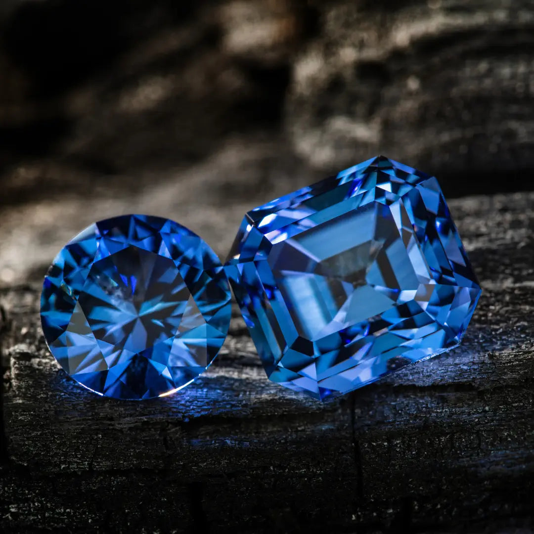 Deux pierres précieuses bleues taillées avec précision reposant sur une surface boisée sombre, illustrant l’élégance et la qualité offerte aux passionnés.
Pierres précieuses d’exception accessibles aux créateurs particuliers.