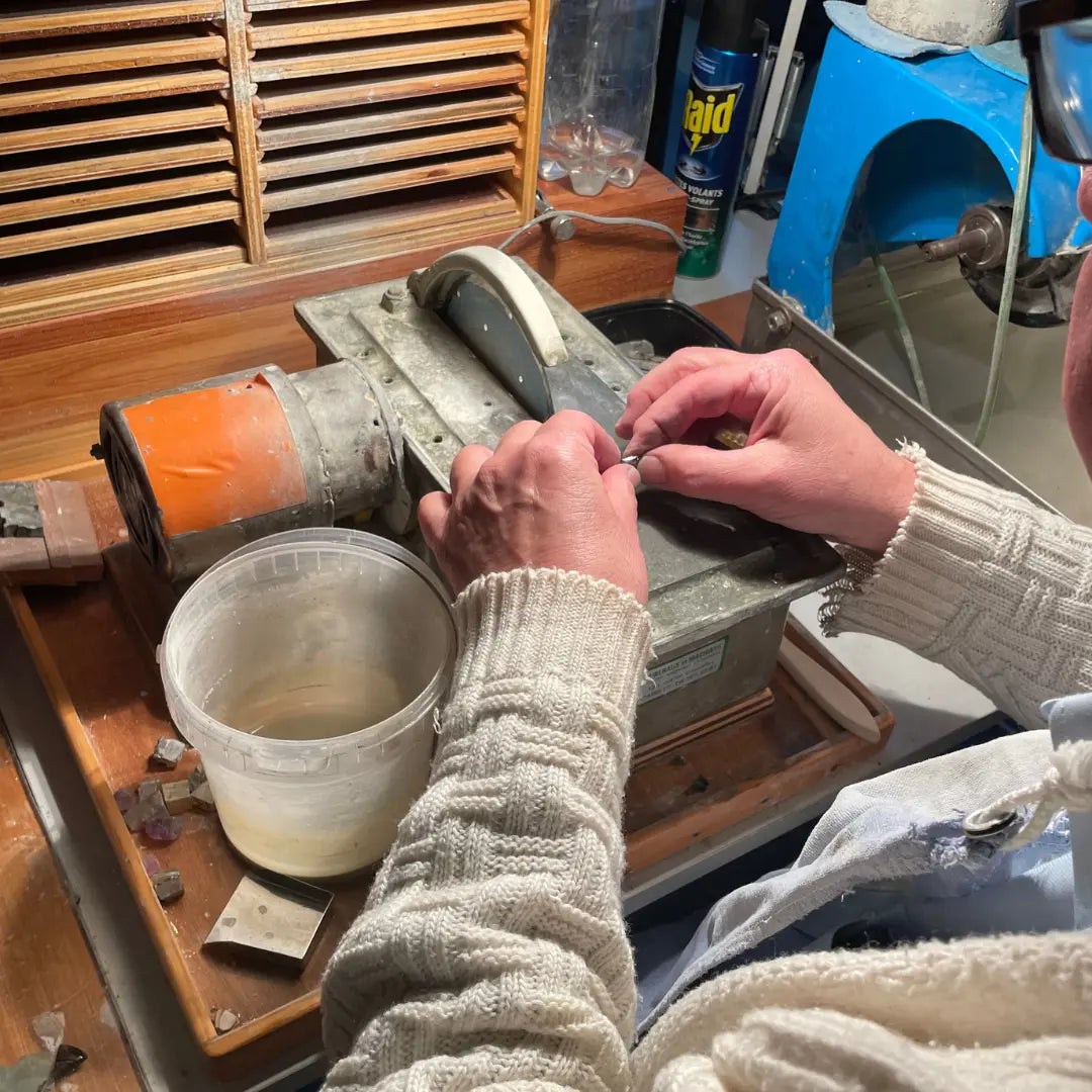 Maître lapidaire français taillant manuellement une pierre précieuse sur meule artisanale dans son atelier.
Collaboration avec un artisan lapidaire pour la taille de pierres précieuses sur mesure.