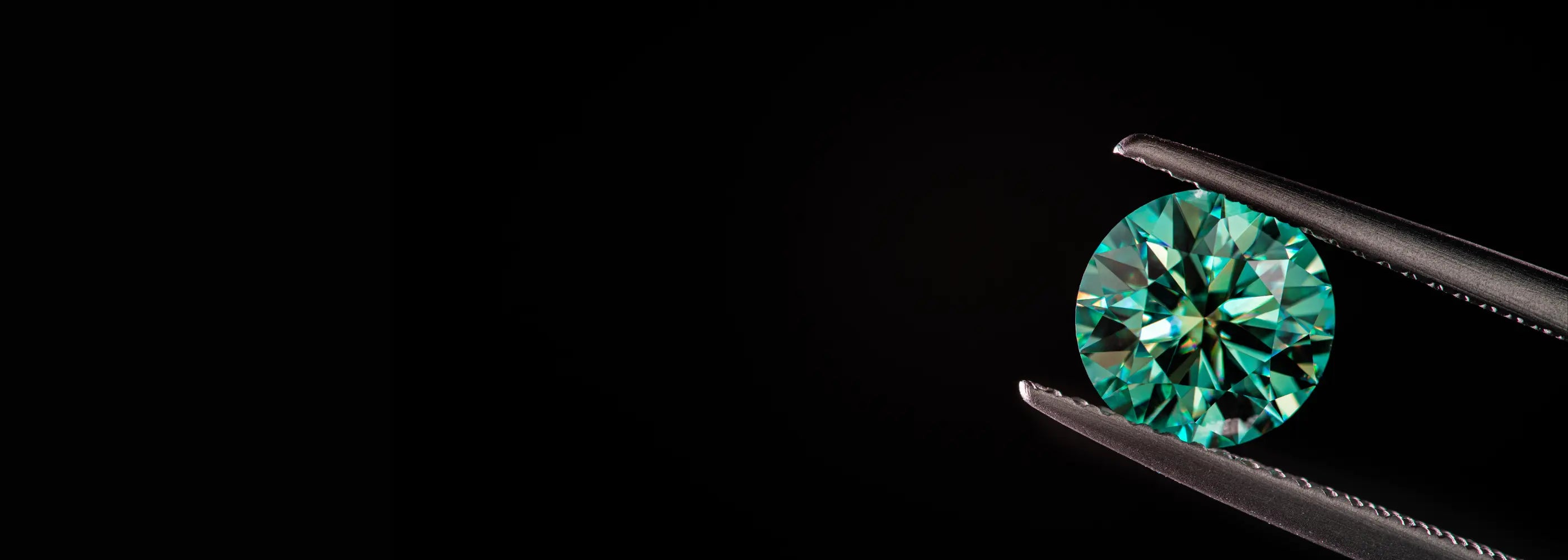 Pierre précieuse verte naturelle, taillée en rond brillant et maintenue délicatement par une pince joaillière sur fond noir. Cette gemme rare et éclatante illustre la finesse du travail lapidaire et la qualité des pierres précieuses proposées par Mael Gems, idéales pour la création de bijoux sur mesure haut de gamme. Mael Gems pierres précieuses à vendre, votre négociant en pierres précieuses.