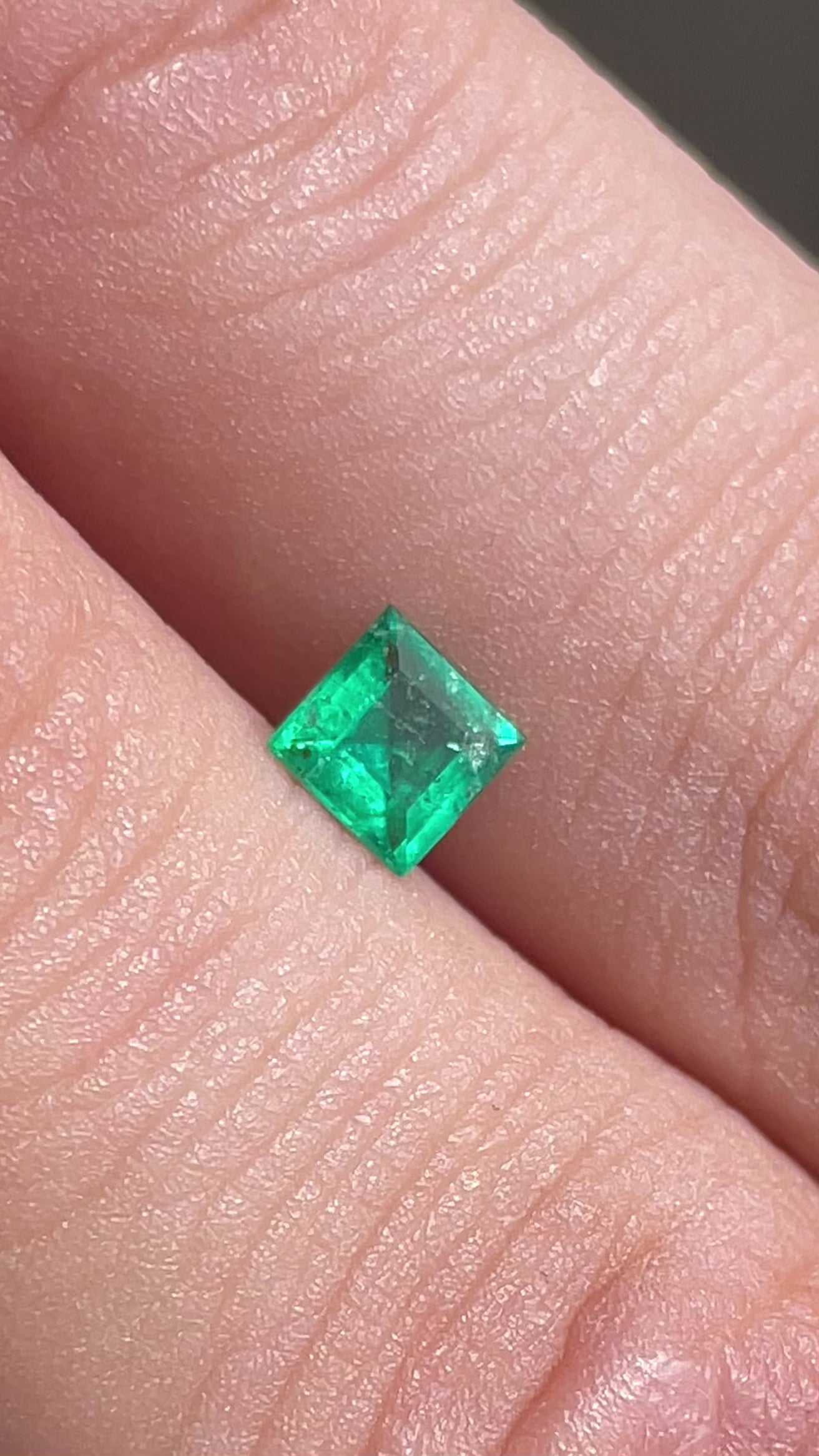 Émeraude verte du Brésil de 0.33 carat en taille carrée, posée sur un doigt – idéale pour bijou discret – Mael Gems