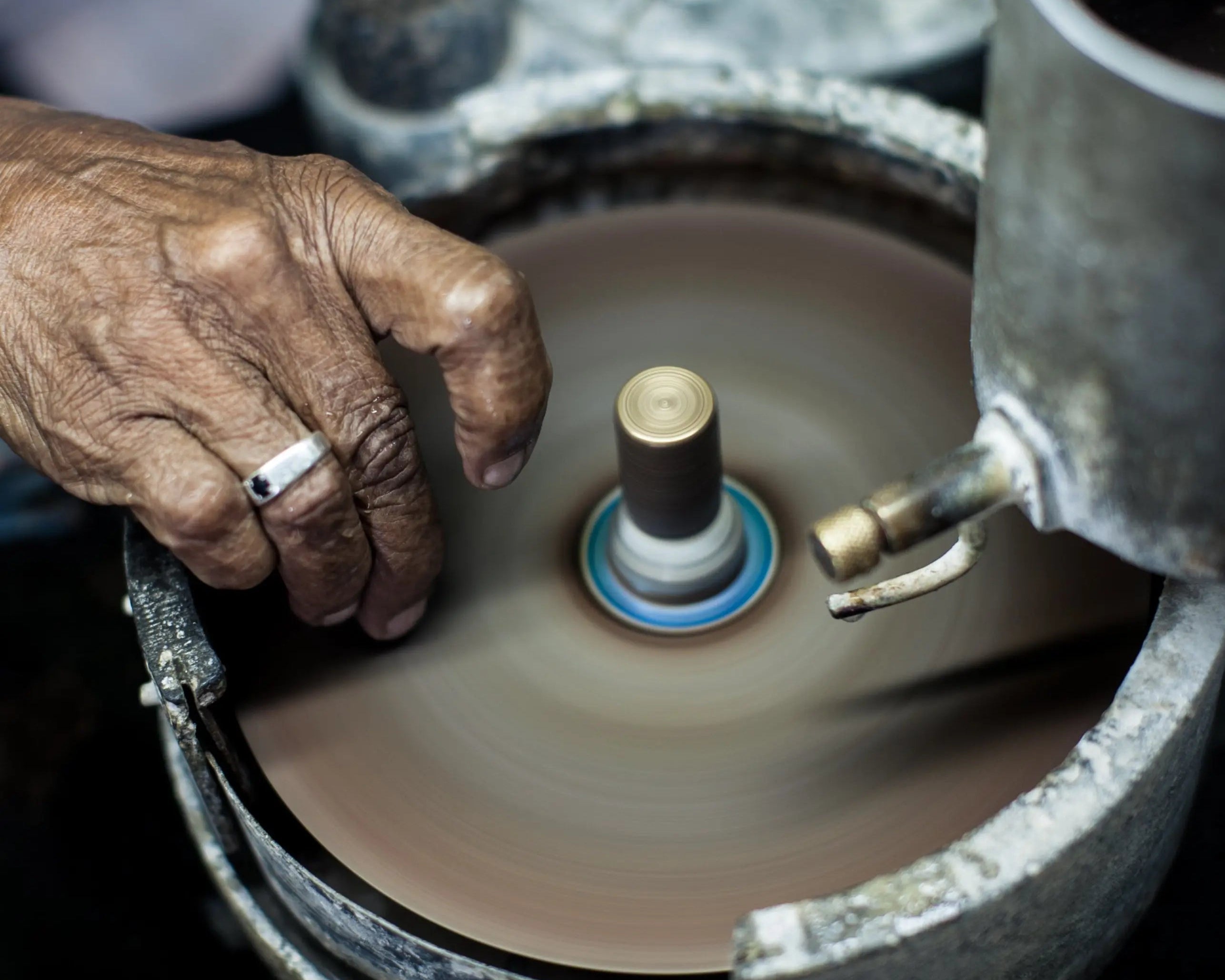 Un lapidaire expérimenté effectue la taille d’une pierre précieuse à l’aide d’un disque rotatif, selon une méthode traditionnelle. Ce savoir-faire artisanal permet de révéler l’éclat naturel de la gemme, en optimisant la réflexion de la lumière et la précision des facettes. Pierres précieuses Mael Gems