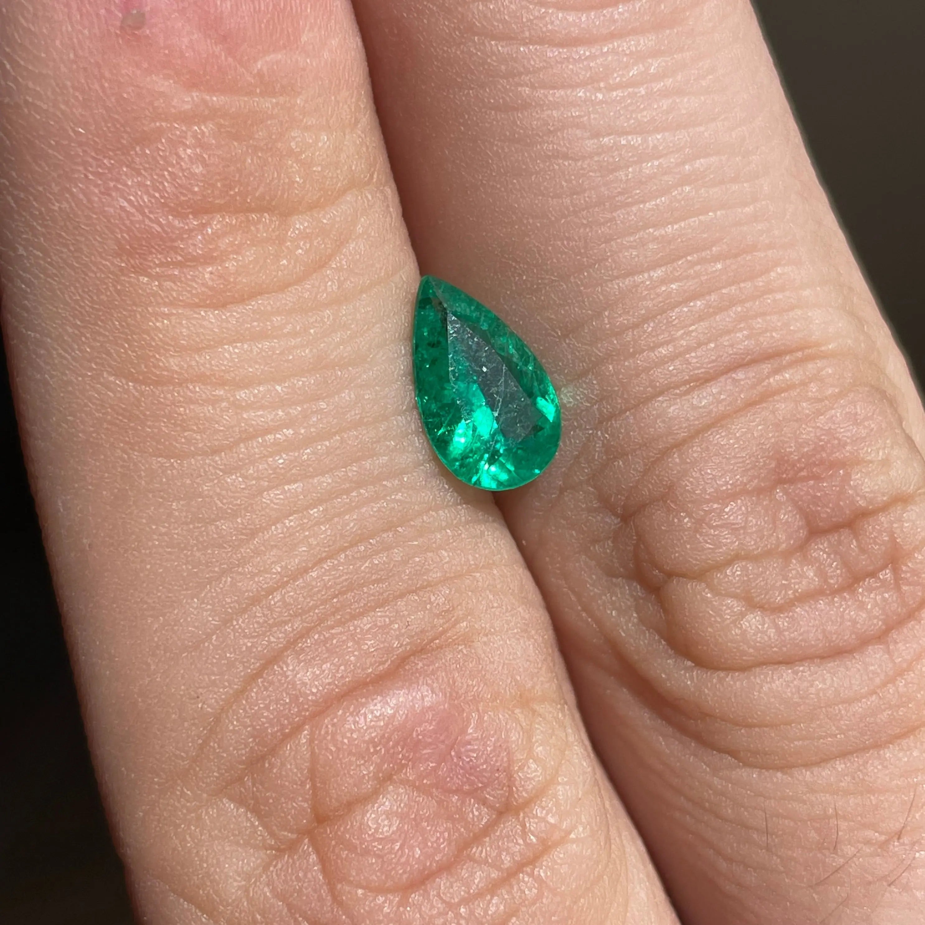 Emeraude-naturelle-0.87ct-Bresil. Émeraude 0.87ct du Brésil posée sur le doigt pour visualiser sa taille réelle.