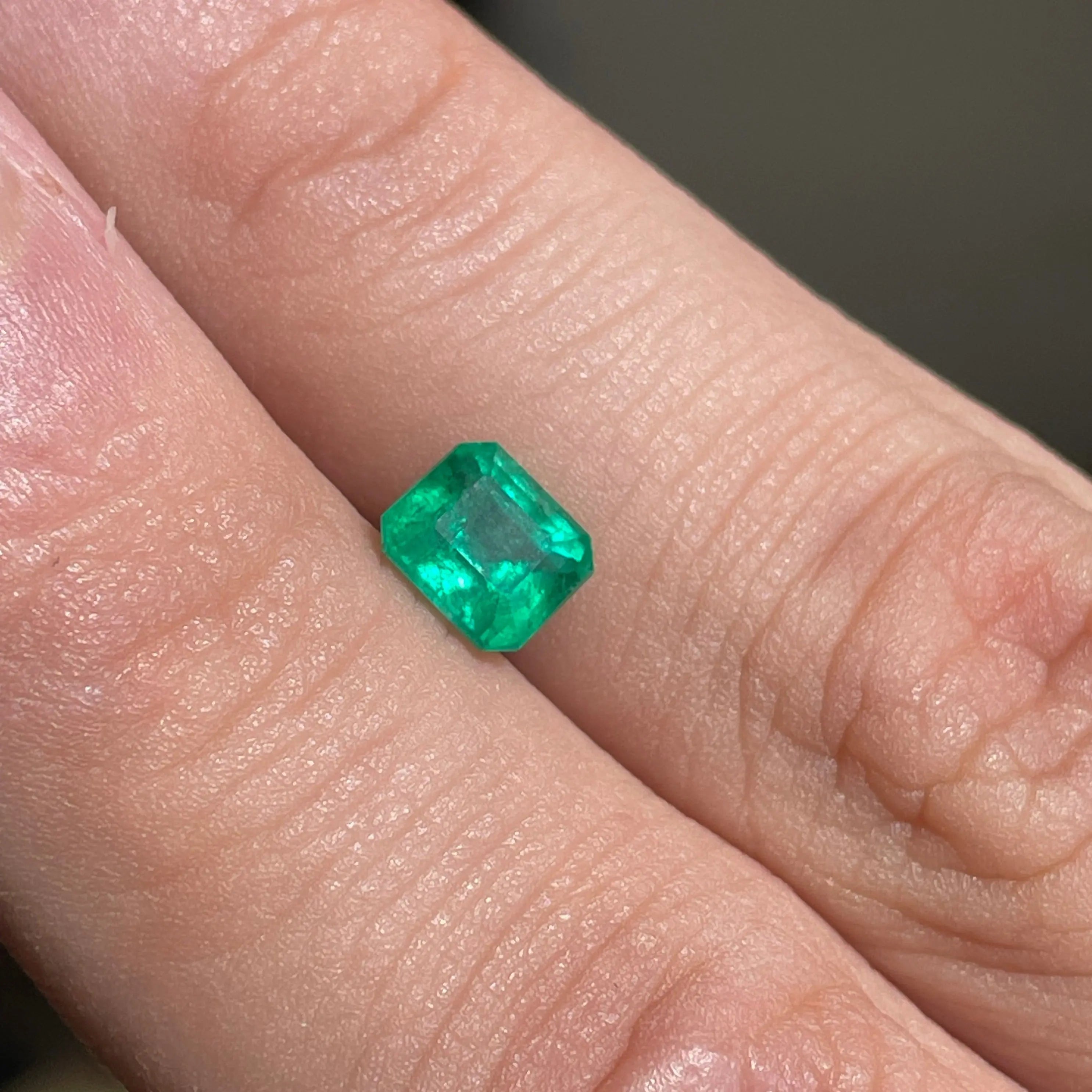 Emeraude-naturelle-1.02ct-Bresil. Émeraude verte naturelle 1.02ct – forme rectangle sur fond noir – Mael Gems