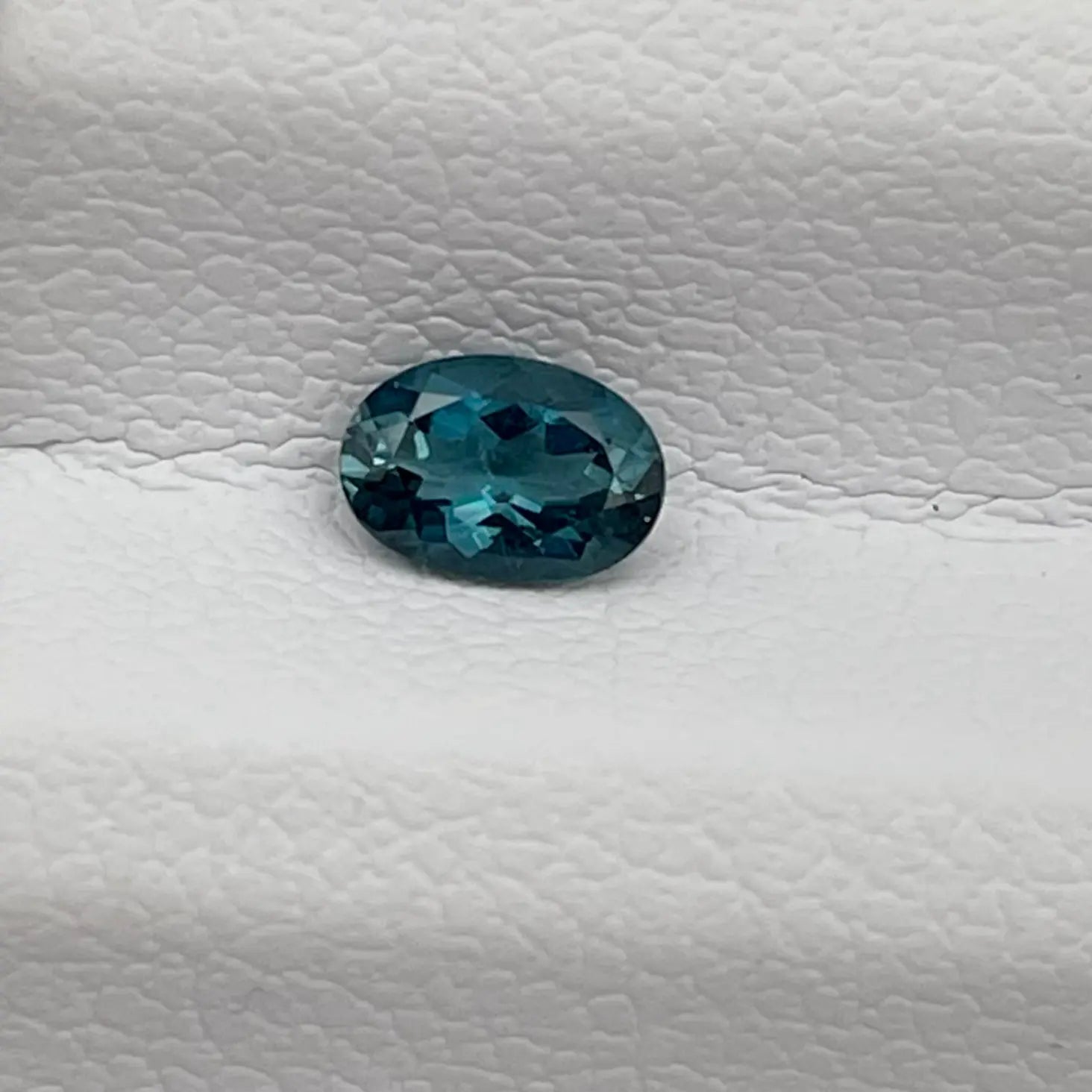 Tourmaline bleue ovale posée sur un écrin blanc, idéale pour un bijou sur-mesure. Tourmaline-Paraiba-Bresil-Cobalt-0.27ct-Sao-Jose-da-Batalha-mael-gems. 
Vue rapprochée d’une tourmaline Paraiba ovale de 0.27 carat, couleur bleu cobalt intense, sur fond clair – origine São José da Batalha, Brésil.

